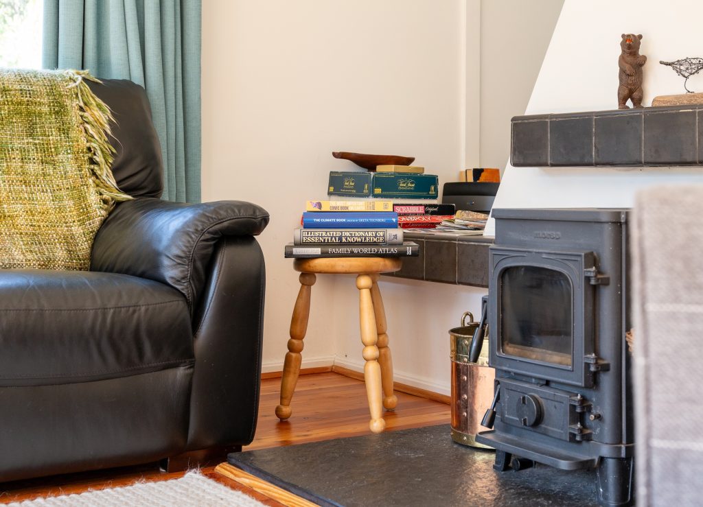 Wood-burning stove and armchairs in the cosy sitting room at Glencoldon Cottage in the Cairngorms